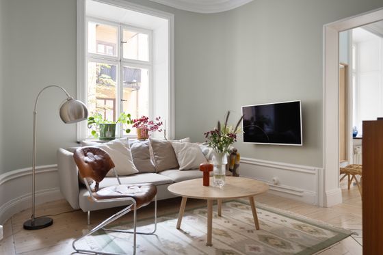 Warm neutral living room with a low sofa and floor lamp. Photo by Lisa Anna on Pexels