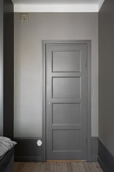 A modern, grey-painted door in a stylish, minimalist room emphasizing simplicity.