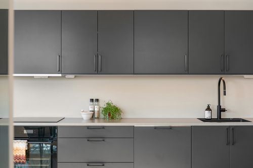 Free A sleek, modern kitchen with dark cabinets, minimalist design, and stylish decor. Stock Photo