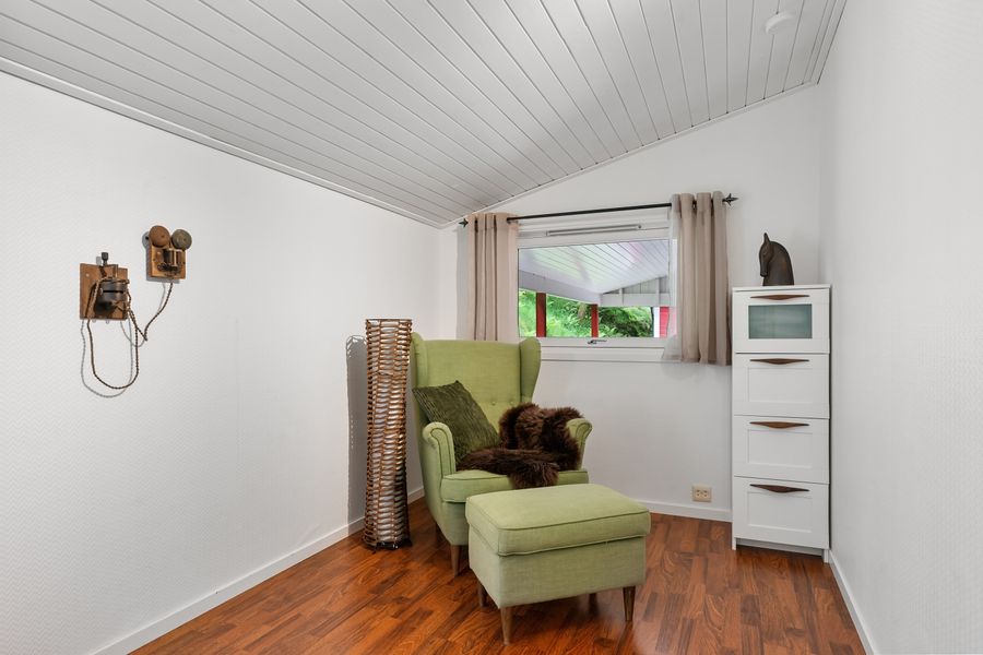 A stylish room featuring a green armchair, wooden accents, and natural light.