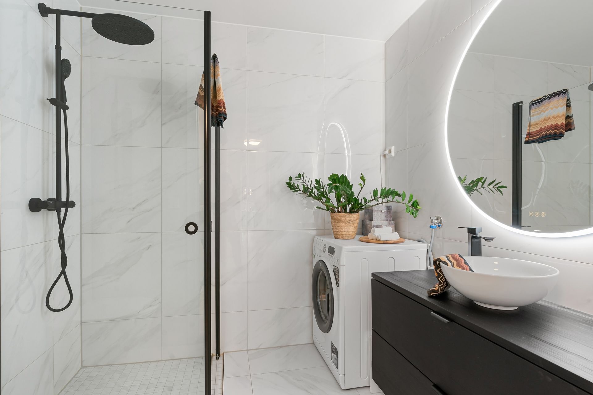 Elegant bathroom interior featuring a minimalist design with shower and laundry area.