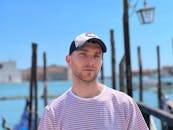 Portrait of a Man in a Striped T-shirt and a Cap Standing Outside in Summer