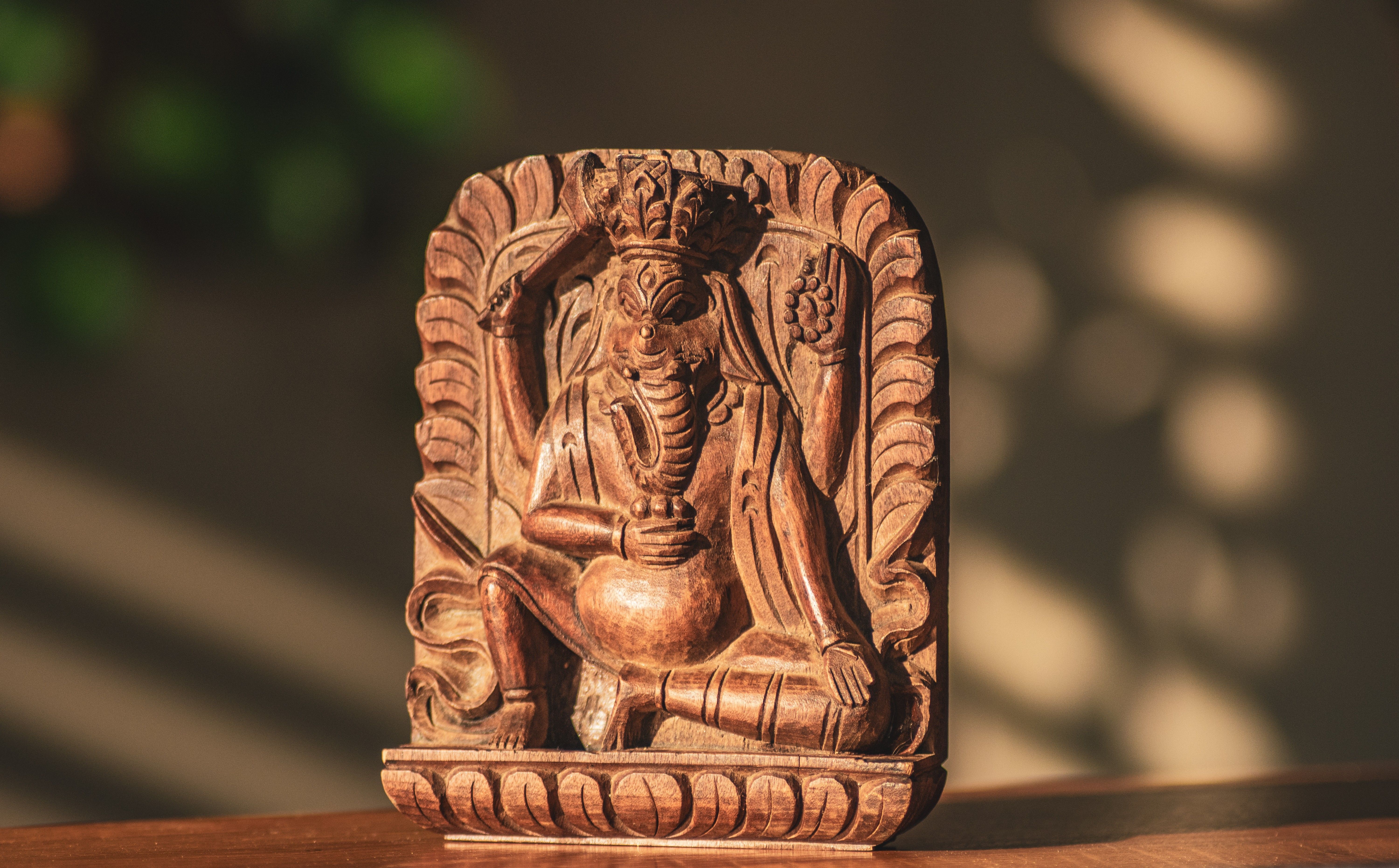 Beautifully carved wooden statue of Ganesh, showcasing traditional craftsmanship and cultural artistry.