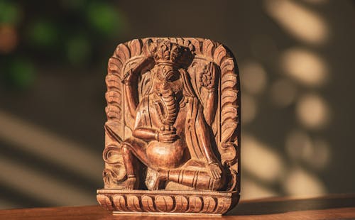 Free A wooden statue of a god sitting on a table Stock Photo