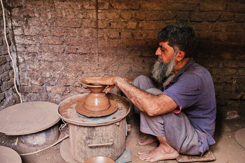Free A man making a pottery bowl in a pottery shop Stock Photo