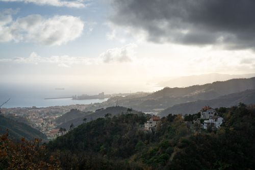 Free Scenic aerial view of Savona, Liguria coastline with hills and ocean at dusk. Stock Photo