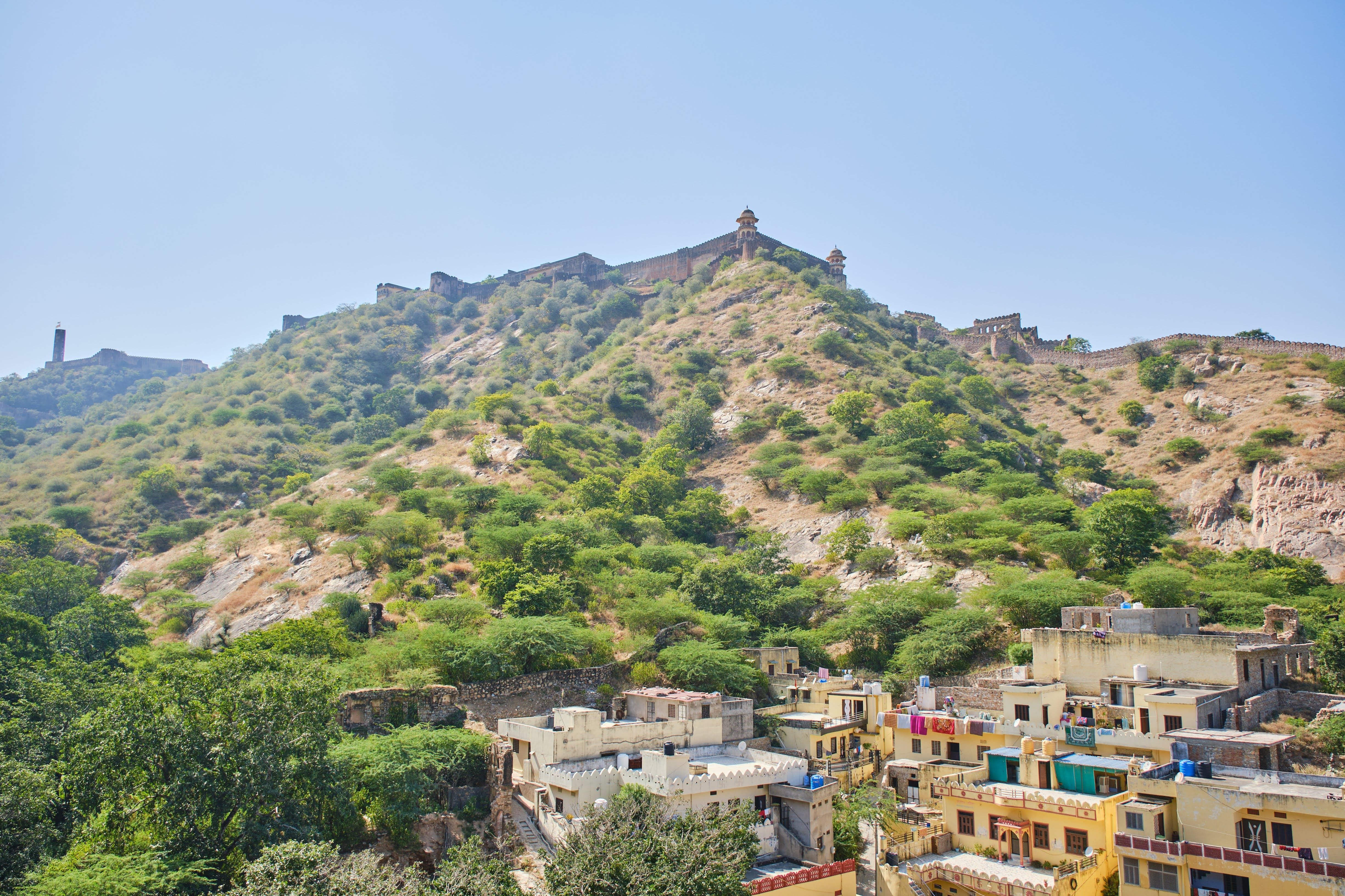 A panoramic view of Jaigarh Fort perched on a hill in Jaipur, surrounded by lush greenery.