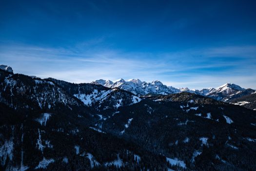 A stunning view of snow-covered mountain peaks under a vibrant blue sky.