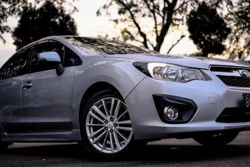 Free Silver Subaru Impreza sports car highlighted against a vibrant sunset backdrop. Perfect for car enthusiasts. Stock Photo