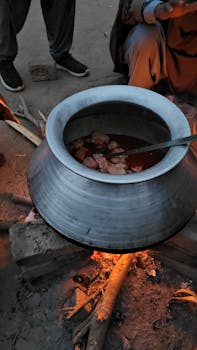 Traditional cooking over a bonfire with a large pot, capturing the essence of outdoor food preparation.
