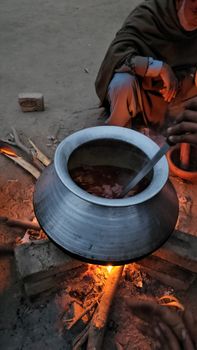 A traditional outdoor cooking setup with a pot over an open fire, capturing a rural ambiance.