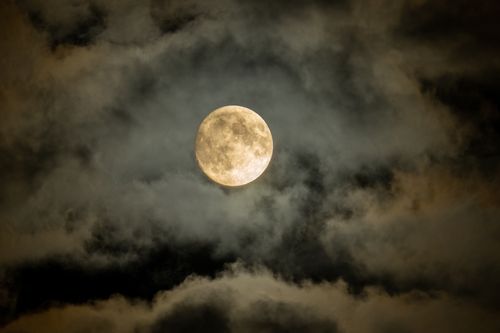 Free A captivating image of a full moon enveloped by dark, eerie clouds in the night sky. Stock Photo
