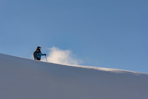 Man Standing on Hill in Snow