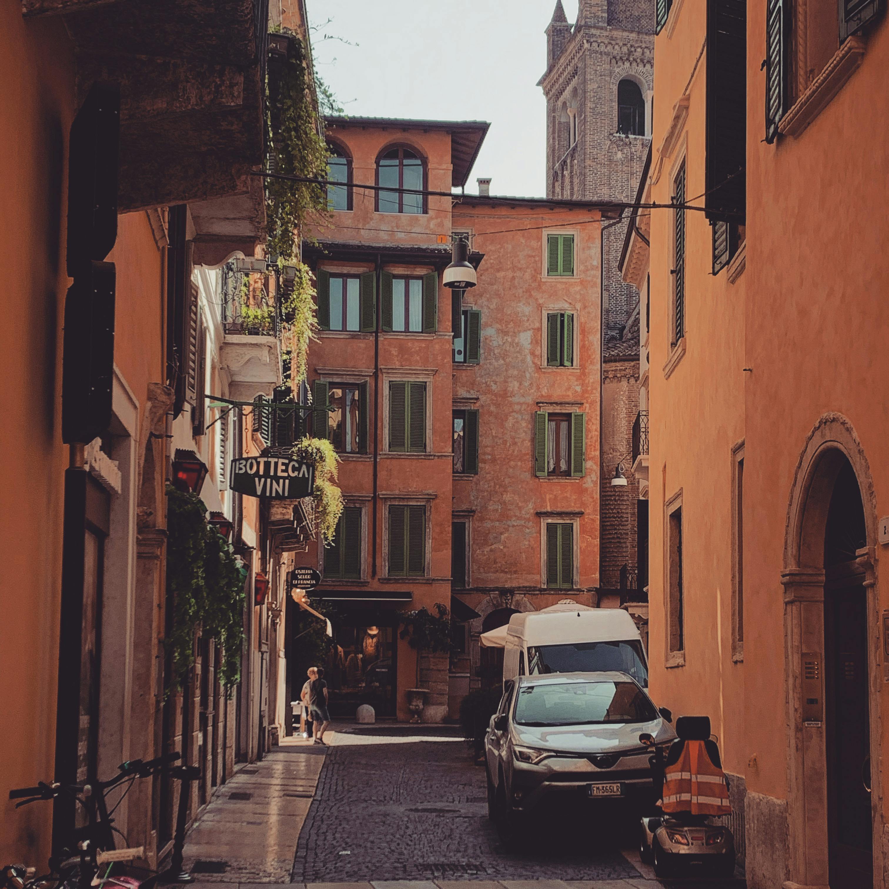 Picturesque narrow street in an Italian town with classic architecture and cobblestone pavement.