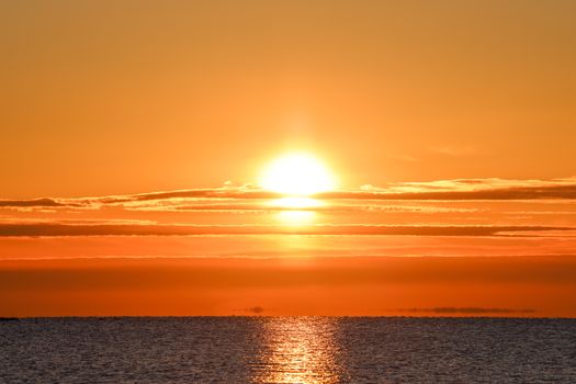 Breathtaking sunset with orange sky reflecting on calm sea, capturing the serene beauty of nature.