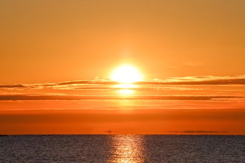 Free Breathtaking sunset with orange sky reflecting on calm sea, capturing the serene beauty of nature. Stock Photo
