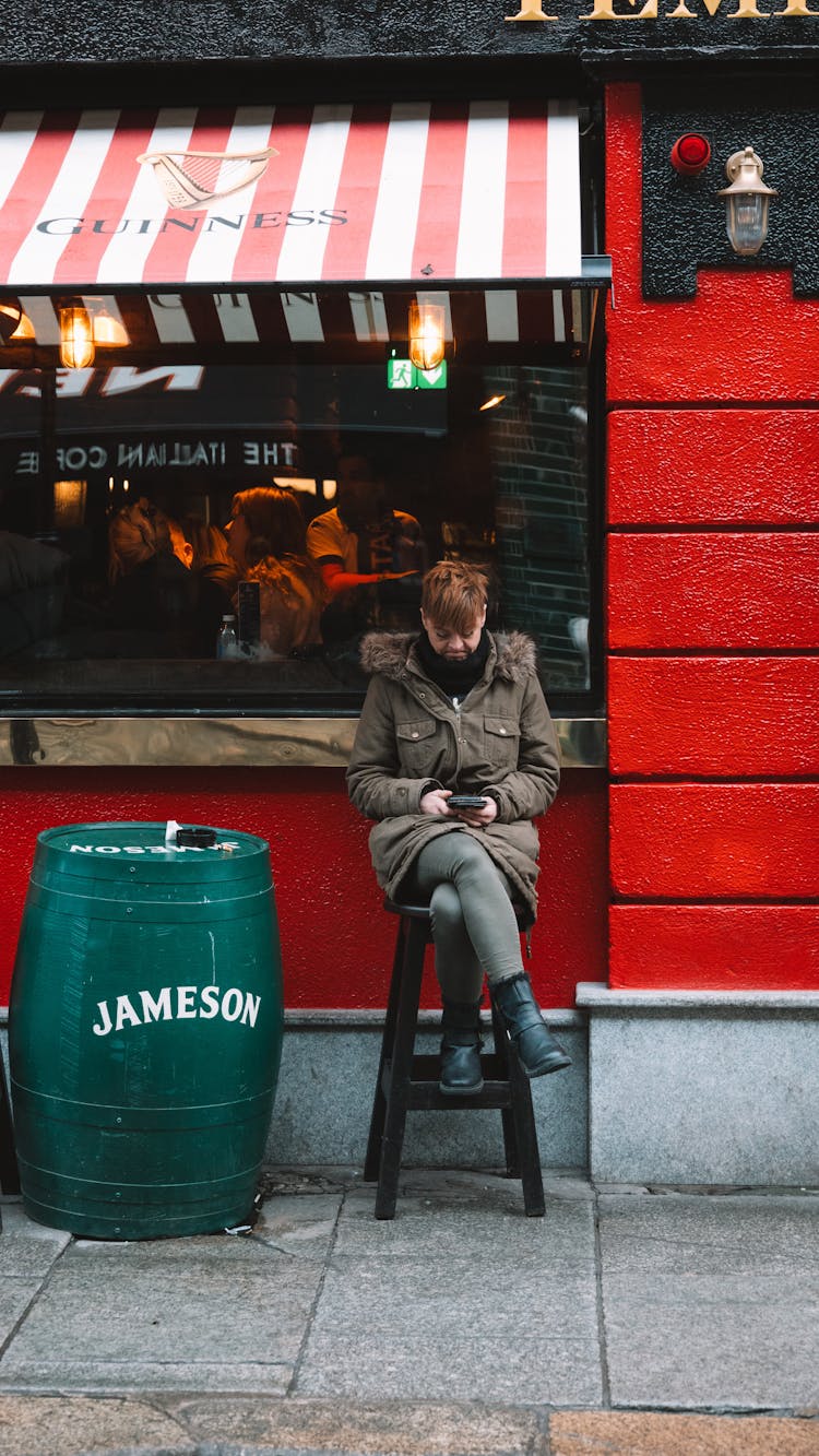 Man In Jacket Sitting On Chair By Bar Window