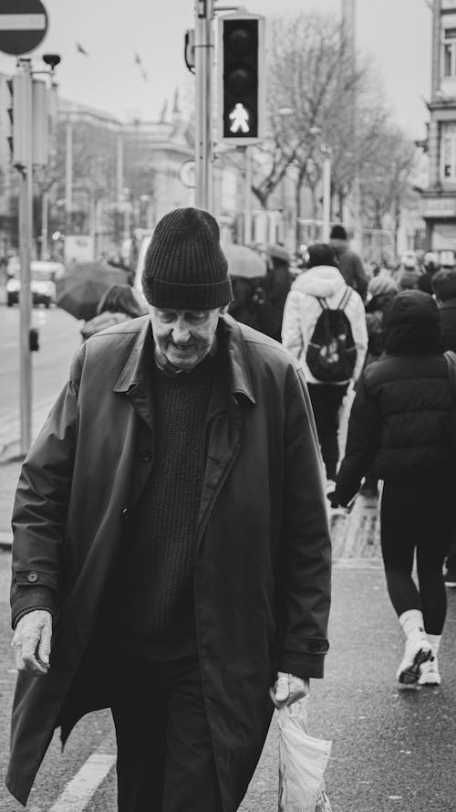 Free A man walking down the street in black and white Stock Photo