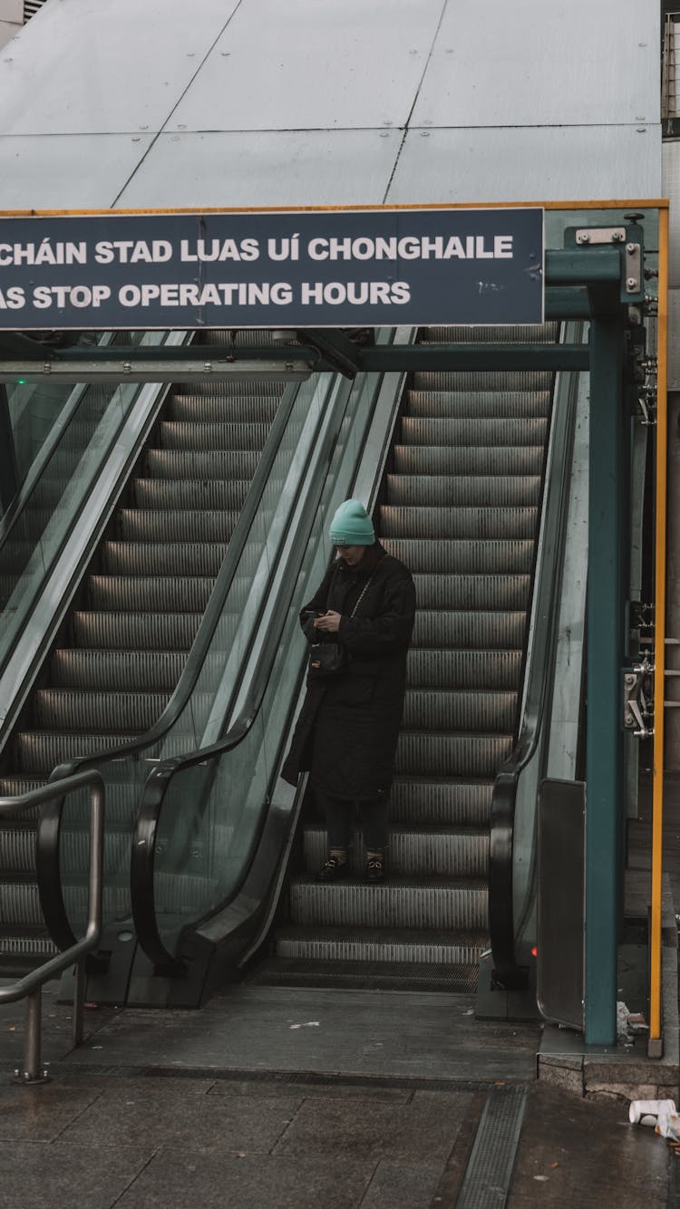 Woman Standing On An Escalator 