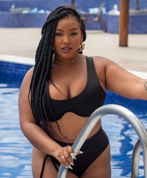Free A woman in a black bikini standing in a pool Stock Photo