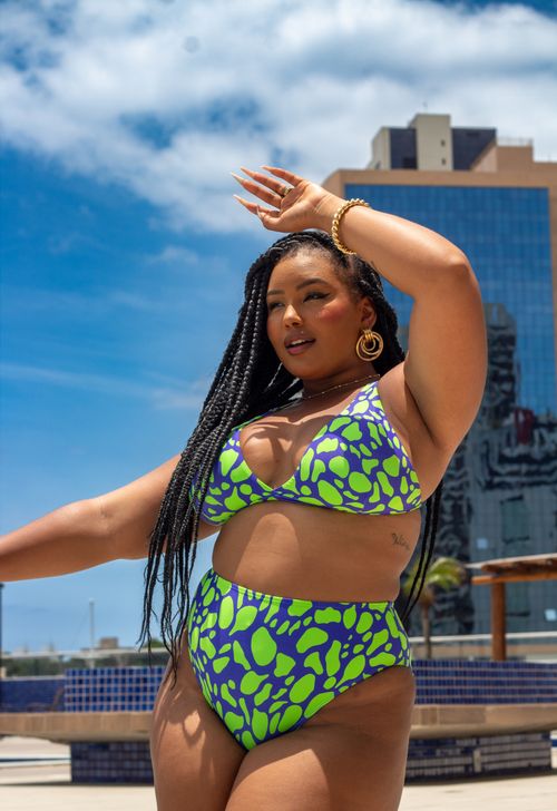 Free A confident woman models a colorful bikini outside in a sunny urban setting. Stock Photo