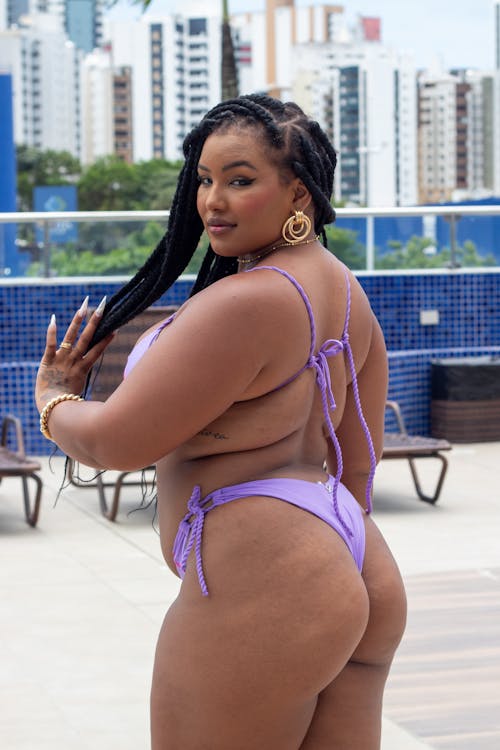 Free A woman in purple bikini standing in front of a pool Stock Photo