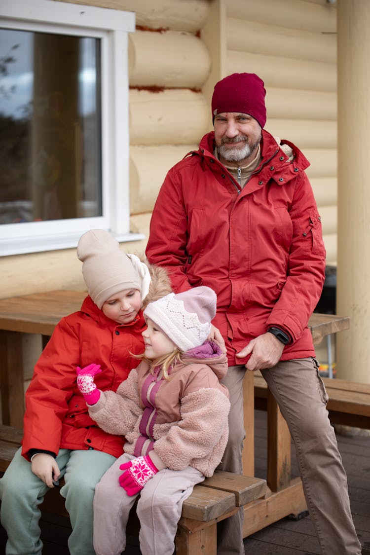 Father Sitting With Children In Jackets