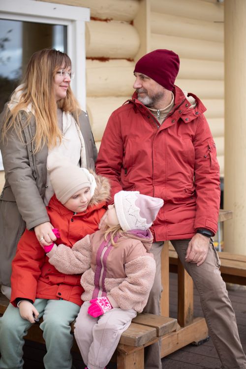 Free Family enjoying a warm gathering outdoors in winter clothing, showcasing togetherness. Stock Photo