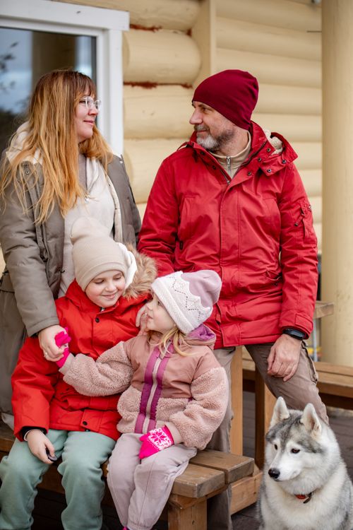 Free A joyful family portrait with kids and a dog, dressed in winter attire, enjoying outdoors. Stock Photo
