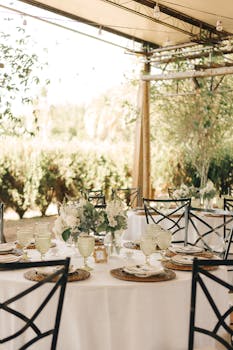 Beautiful outdoor wedding reception setup with elegant table decor and floral centerpieces.