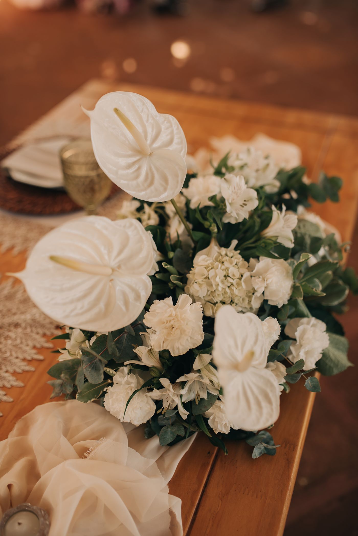 White floral arrangement and refined tableware prepared for a special gathering