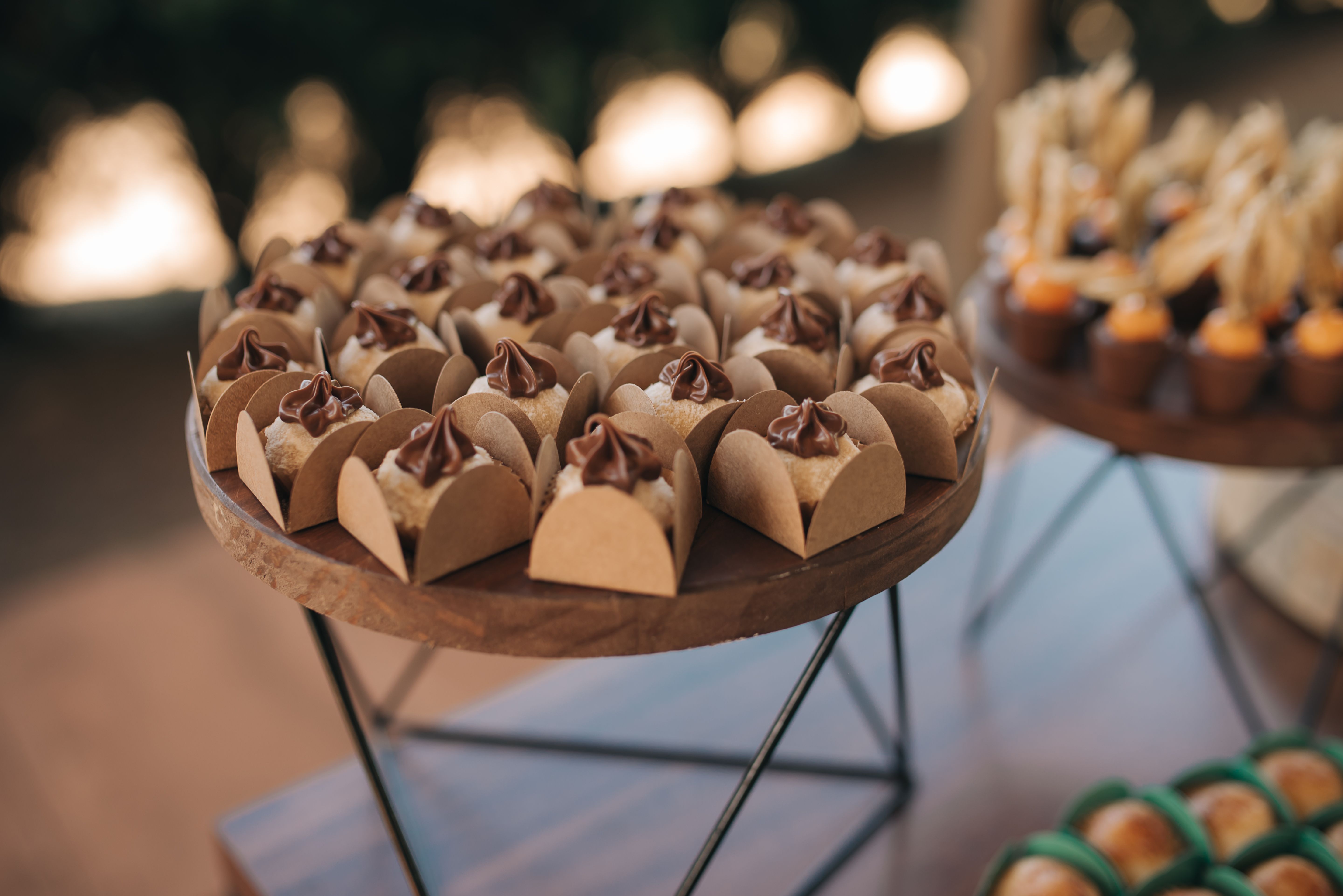 Indulge in a selection of chocolate sweets elegantly presented on a stylish wooden stand, perfect for events.