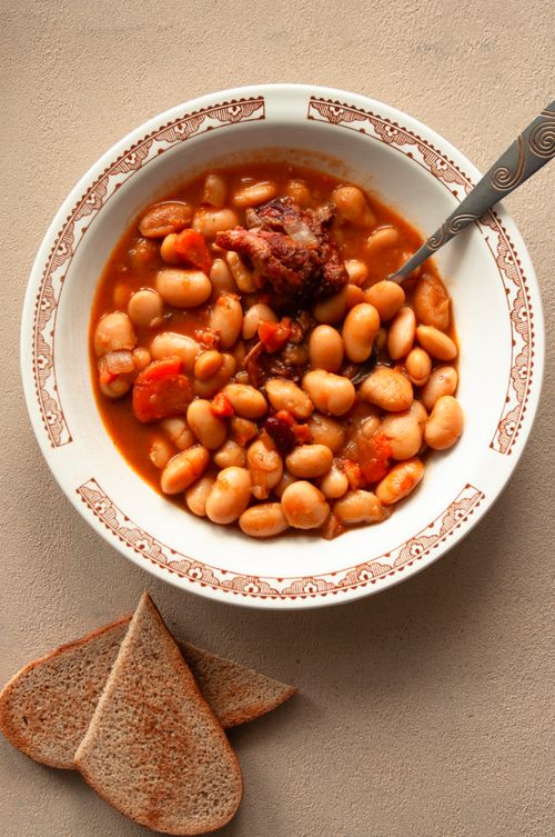 Free A top view of a warm, hearty bean stew served with fresh bread slices. Stock Photo