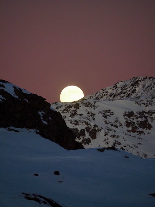 Moon Rising over Snow Covered Mountains 