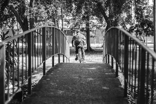 Man Cycling at Park in Black and White