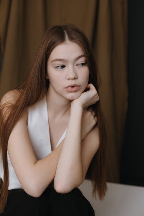 Portrait of Woman Sitting in White Vest