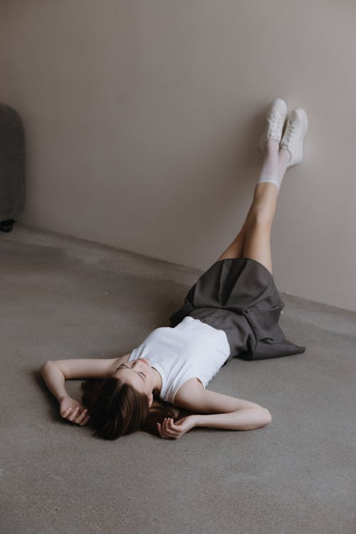 Free Woman in Skirt Lying Down with Legs Raised Stock Photo