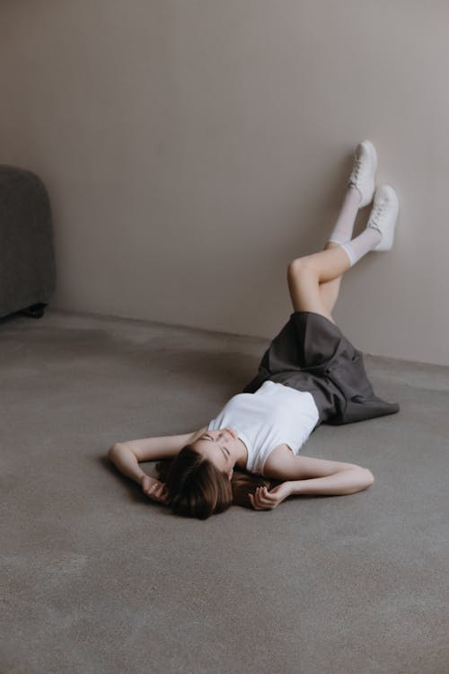 Free Woman in Skirt Lying Down on Floor Stock Photo