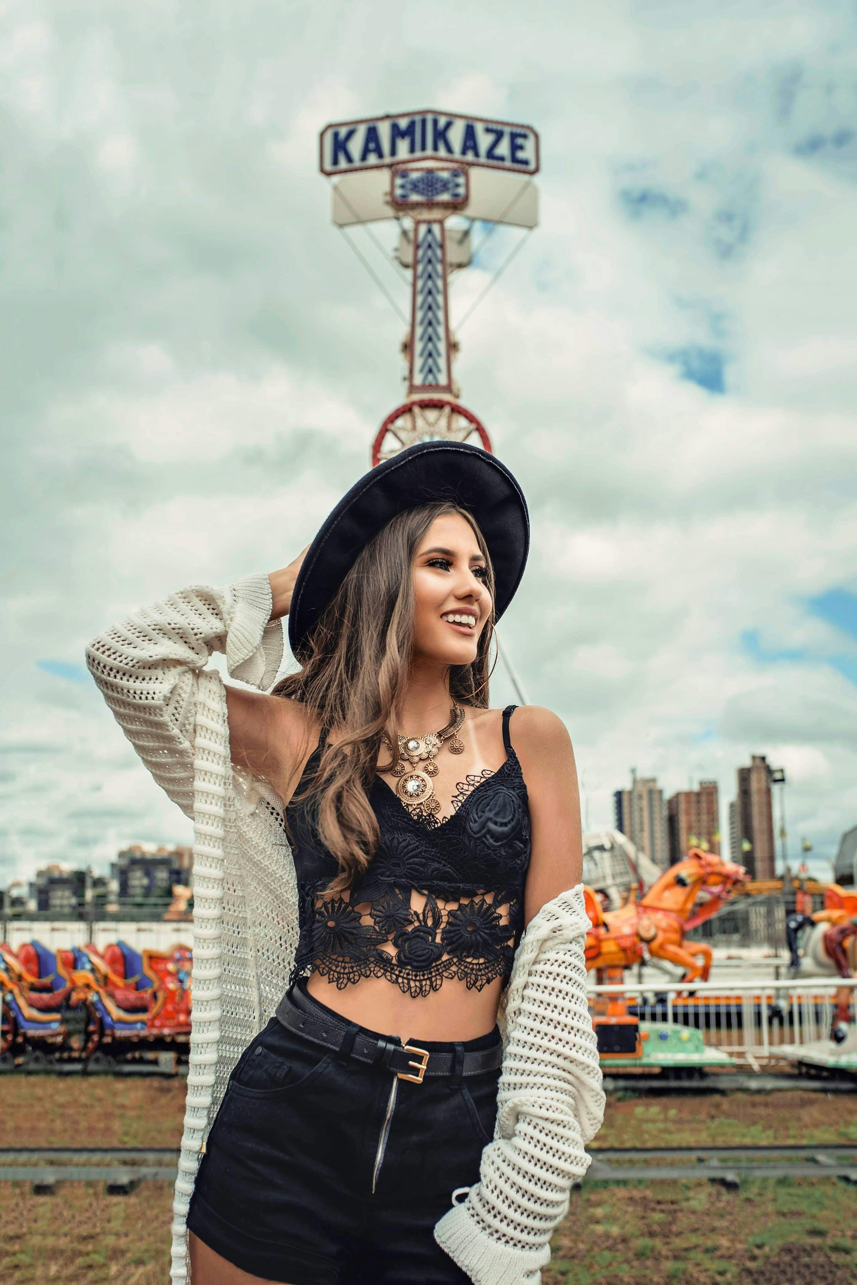 Woman Wearing Black Hat, White Cardigan, and Black Lace Crop Top