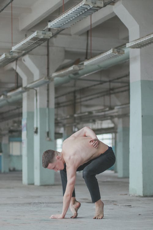 Topless Mężczyzna Robi ćwiczenia W Pobliżu Białego Budynku