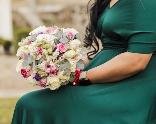 Sitting Woman in Green Dress and with Flowers Bouquet