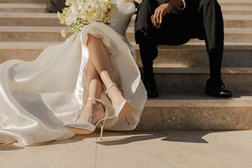 Legs of Newlyweds Sitting on Stairs