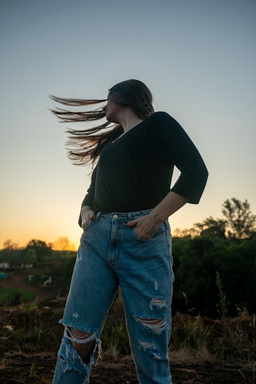 Portrait of Woman in Torn Jeans at Sunset