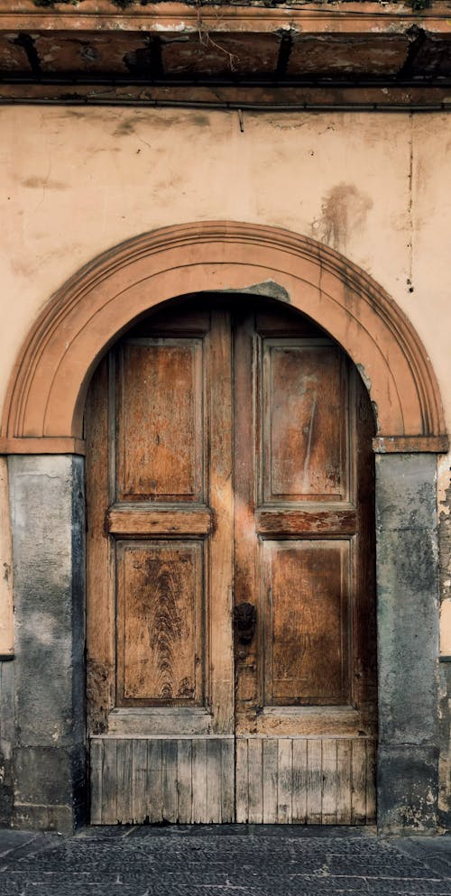 A door with a wooden frame and a stone wall