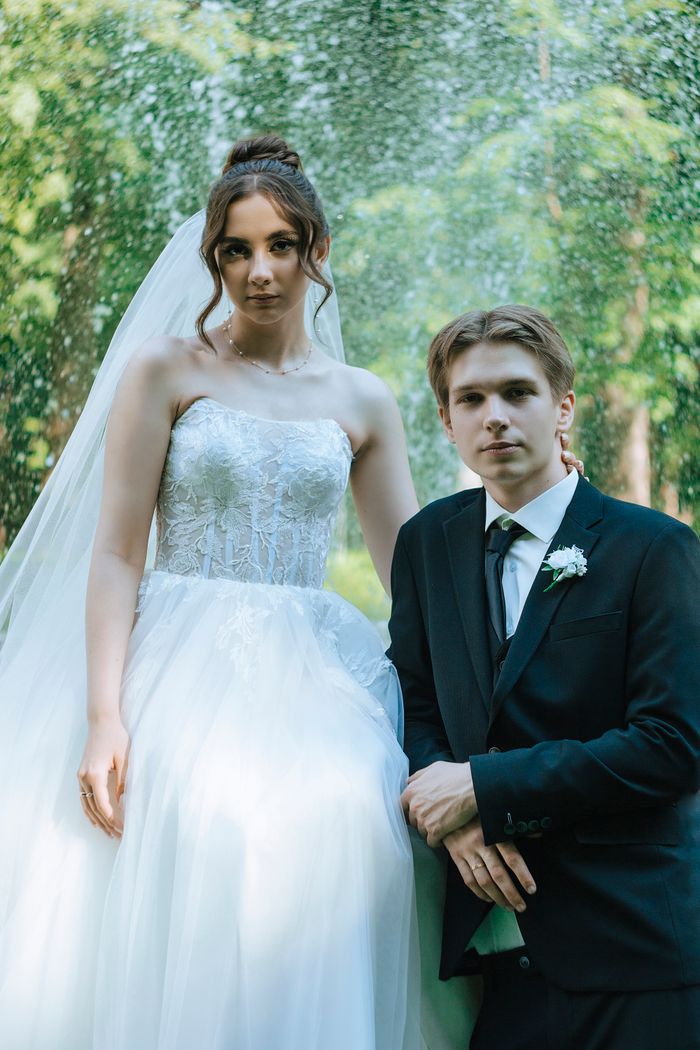 Couple posing elegantly in a sunlit garden