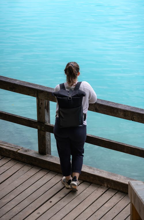 A woman with a backpack looking out over a body of water