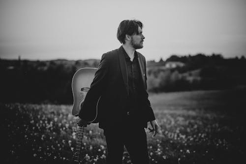 Man with Guitar on Meadow in Black and White