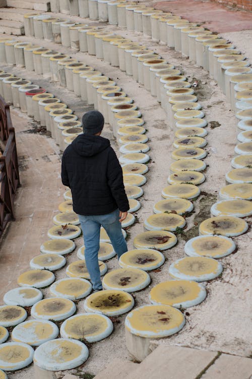 Man Walking near Stone Theater Seats