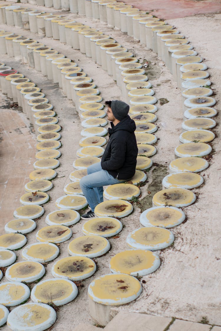 Man Sitting On Stone Theater Seats