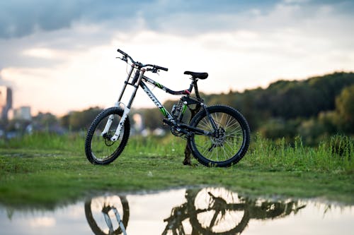 Bike on Grass and Reflection in Puddle